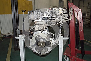 Rear view of the assembled car engine mounted on the engine repair stand