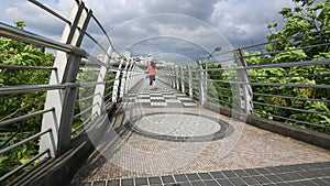 Rear view Athletic running fitness asian woman in a bridge of urban city