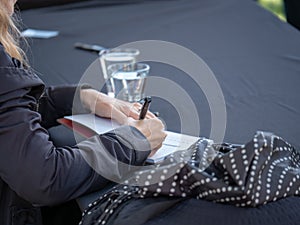 A rear view of author autographing book for fans