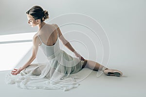 rear view of ballerina sitting in white dress