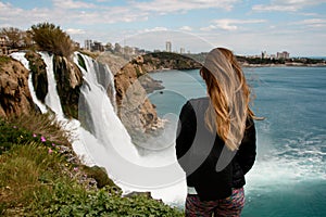 rear view of beautiful woman on background of Duden waterfall in Antalya,Turkey.