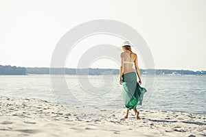 Rear view of beautiful woman in green silk walking