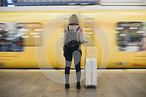 Rear view of a blond woman waiting at the train platform