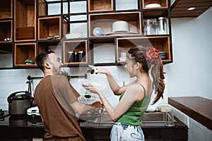 rear view of boy and girl joking while washing dishes