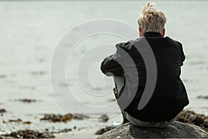 Rear view of boy watching the tides on beach