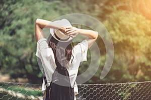 Rear view of brunette girl in park in straw hat.