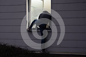 Burglar Entering House Through Window photo