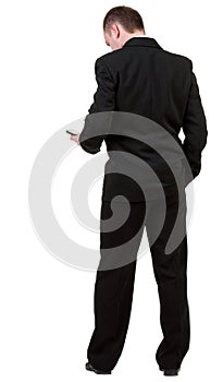 Rear view of business man in black suit talking on mobile phon