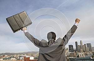 Rear View Of Businessman With Arms Out In Front Of Buildings