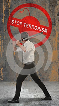 Rear view of a businessman holding a baseball bat with a stop terrorism sign