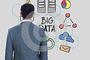 Rear view of businessman looking at big data text and icons