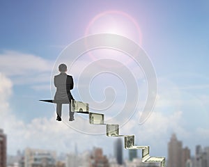 Rear view businessman sitting on top of money stairs