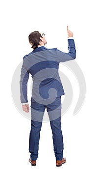 Rear view businessman in suit pointing up index finger, full length portrait isolated on white background. Business analysis