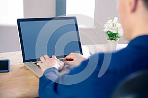 Rear view of businessman typing on his laptop