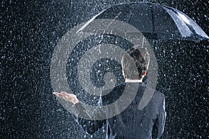 Rear View Of Businessman Under Umbrella In Rain