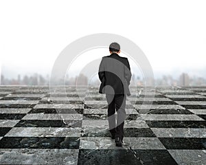 Rear view businessman walking on chessboard