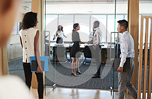 Rear View Of Businesspeople Entering Boardroom For Meeting