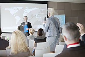 Rear view of businesswoman answering questions during seminar