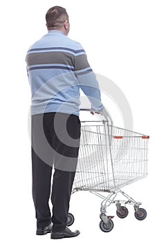 rear view. casual man with a cart standing in front of a white screen