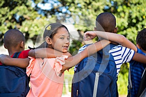 Rear view of classmates with arms around at campus