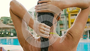 Rear view close-up, woman washing her hair in a shower outdoors. HD