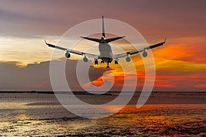 Rear view commercial passenger aircraft or cargo transportation airplane fly over coast of sea after takeoff from airport in