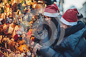 Rear view of couple on christmas market looking at decorative to