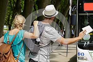 rear view couple flagging down bus