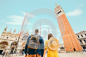 rear view of couple holding hands at saint marks square venice italy