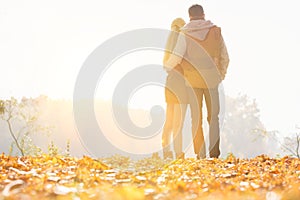 Rear view of couple looking at view in park during autumn