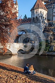 Rear view of a couple sitting in front of Vajdahunyad castle in Budapest, Hungary