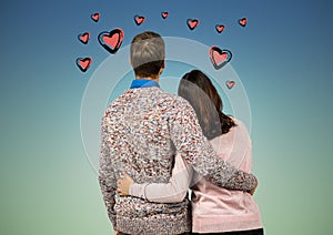 Rear view of couple standing with arms around