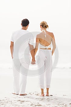 Rear view of couple standing on the beach