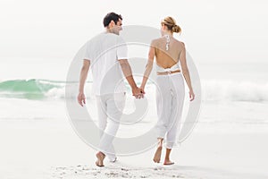 Rear view of couple walking on the beach