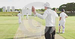 Rear view of cricket umpire making signs