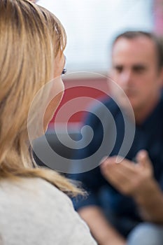 Rear View Of Depressed Mature Woman Talking To Counselor