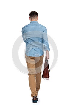 Rear view of a determined casual man holding briefcase