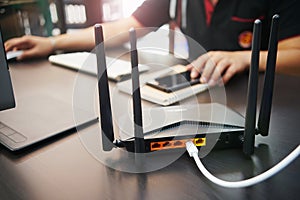 Rear view of Dual Band Router or Wireless AC router with business man using a computer in home office background . Computers and