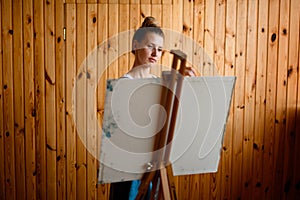 Rear view of easel with canvas behind which is artist.