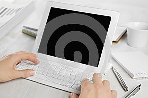 Rear view of employee hands working on tablet computer keyboard