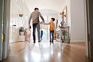 Rear View Of Family Leaving Home On Trip Out With Excited Children