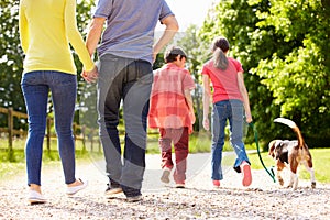 Rear View Of Family Taking Dog For Walk