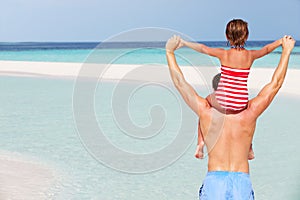 Rear View Of Father Carrying Daughter On Beach Holiday