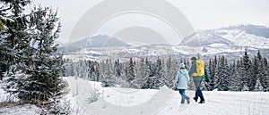 Pohľad zozadu na otca s malou dcérkou na prechádzke vonku v zimnej prírode, Tatry Slovensko.