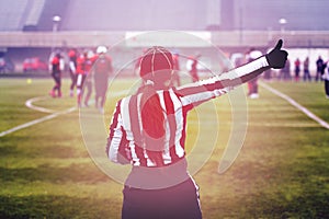 Rear view of female american football referee