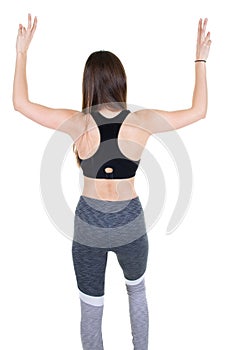 Rear view of a female athlete standing with hands arms up against white background