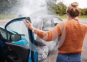 Rear View Of Female Motorist With Head Injury Getting Out Of Car After Crash