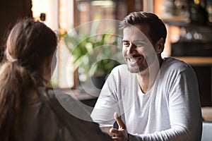 Rear view female sitting at speed dating with smiling man