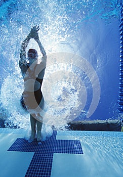 Rear view of female swimmer in competition