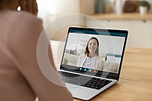 Rear view of female teacher talk to student using laptop